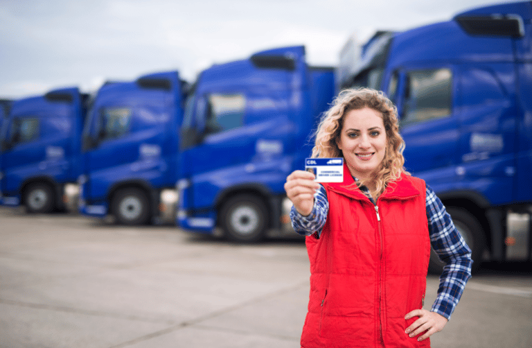 A female trucker holding her CDL license up.
